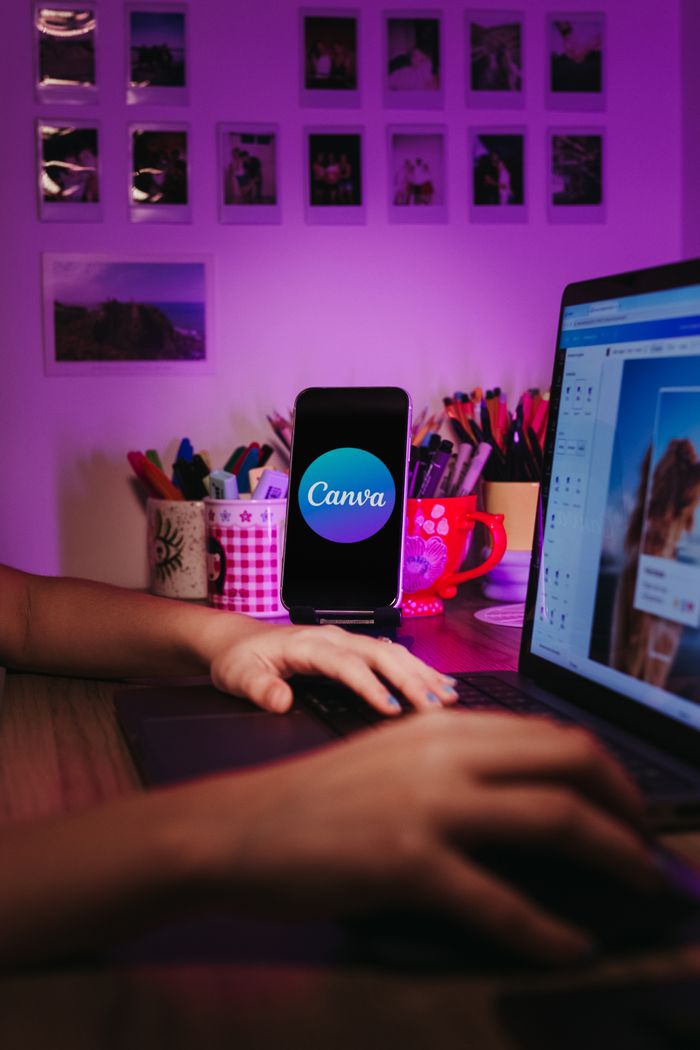 why-choose-us A creative home workspace with a laptop and smartphone displaying Canva, showcasing a vibrant, organized desk setup.