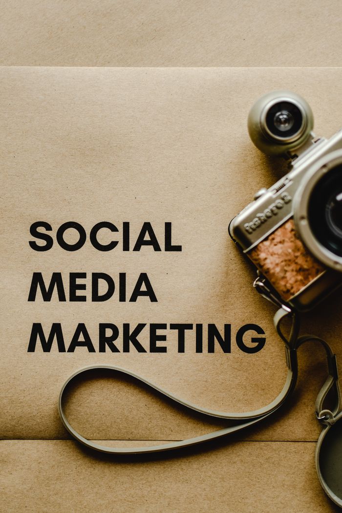 services-02 Close-up of a vintage camera next to a social media marketing concept text on a brown background.