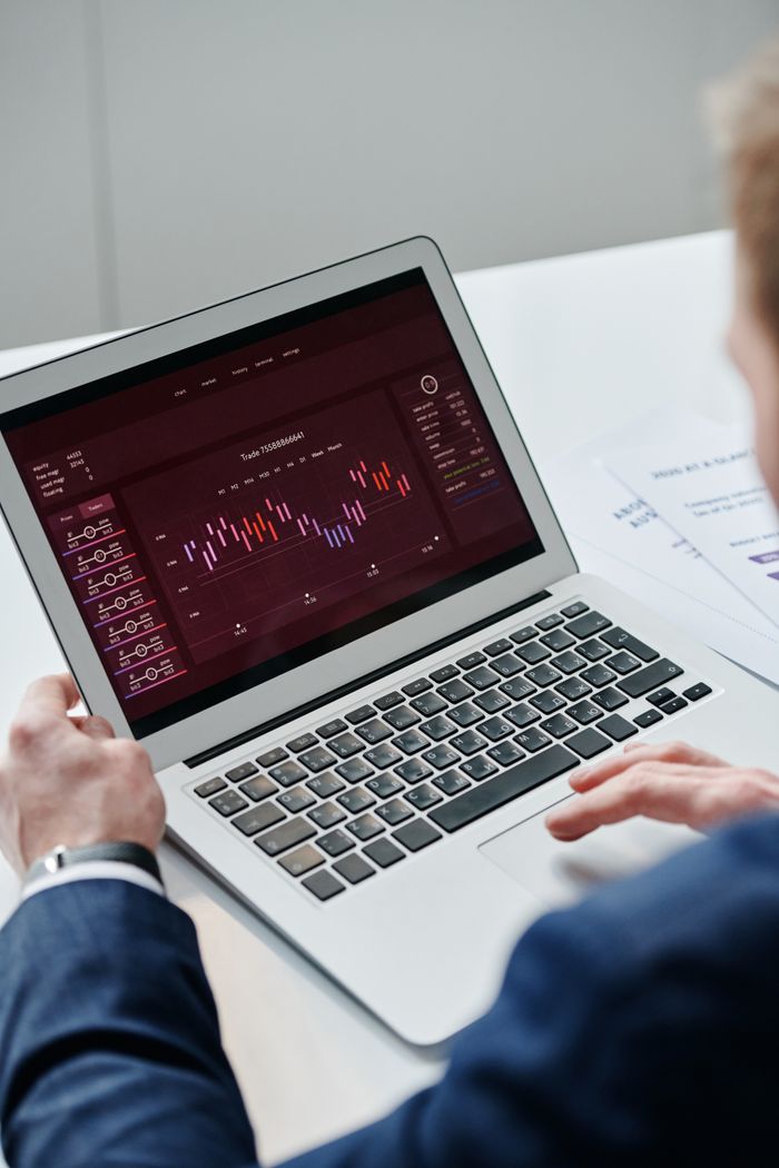 services-01 Businessman analyzing trading data on laptop with financial chart on screen, highlighting finance and technology.